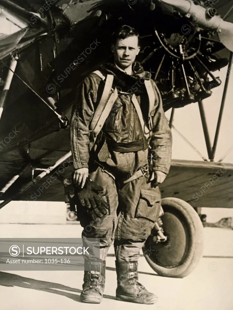 Portrait of a fighter pilot standing near a military aircraft