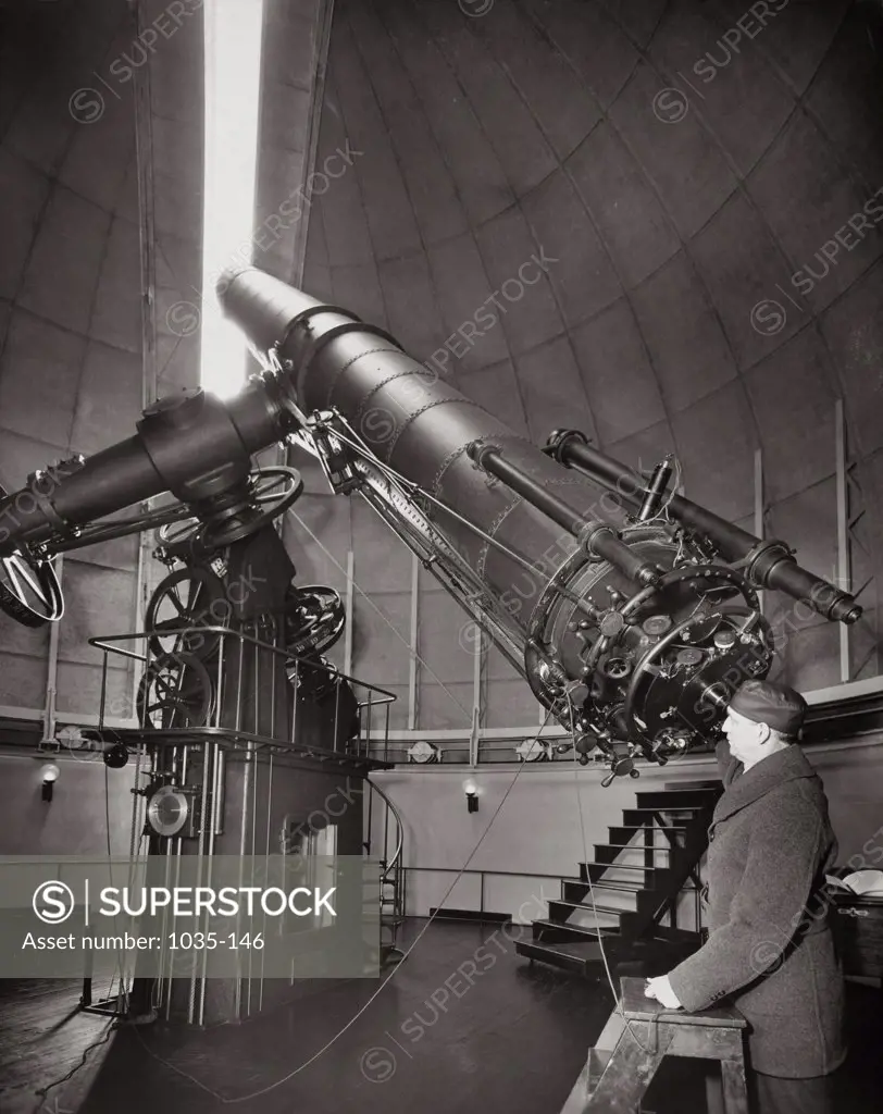 Side profile of a mature man looking through a refracting telescope, Naval Observatory, Washington D.C., USA, 1937