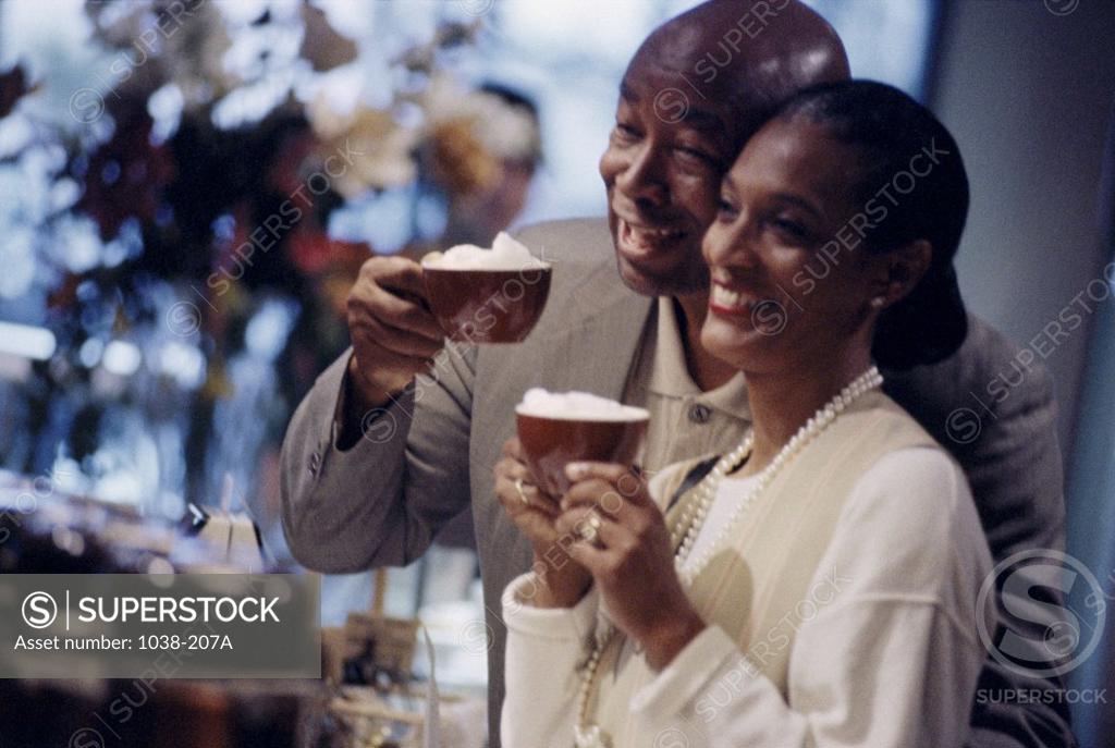 Stock Photo: 1038-207A Mid adult couple holding cups of cappuccino