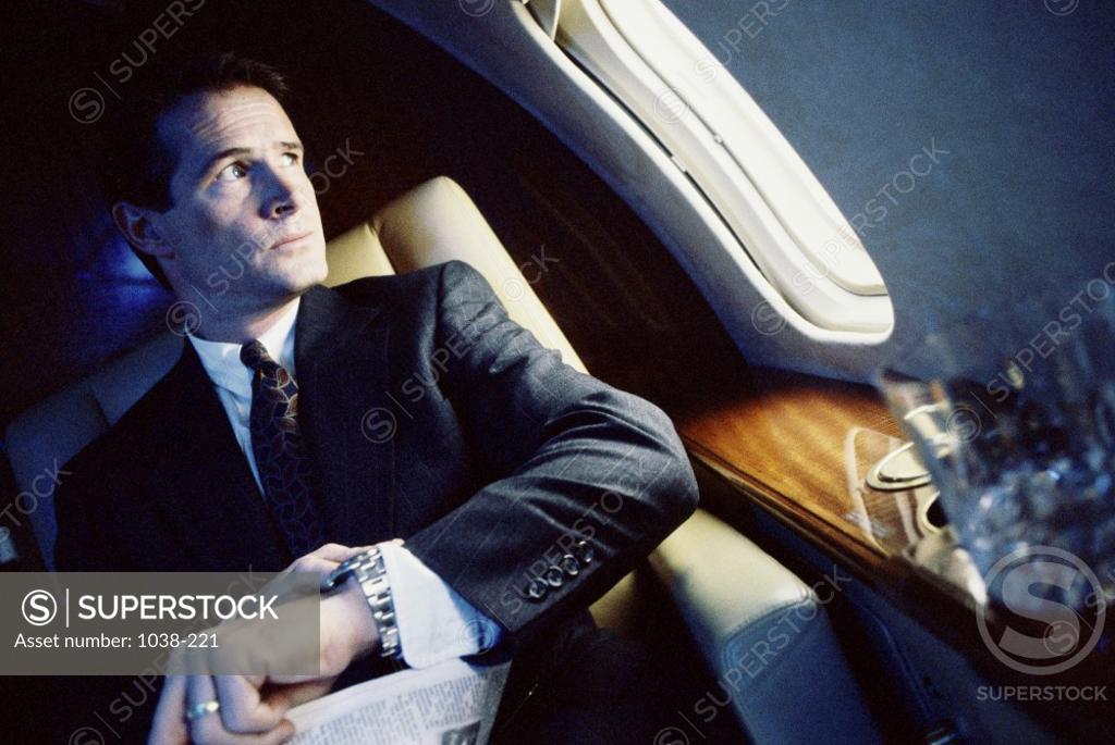 Stock Photo: 1038-221 Businessman looking out of an airplane window