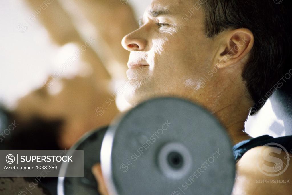 Stock Photo: 1038-284 Close-up of a mid adult man exercising with dumbbells