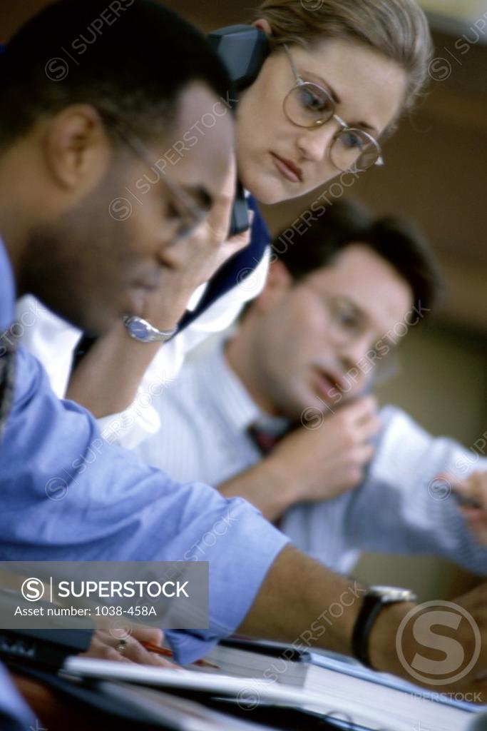 Stock Photo: 1038-458A Two businessmen and a businesswoman in a meeting