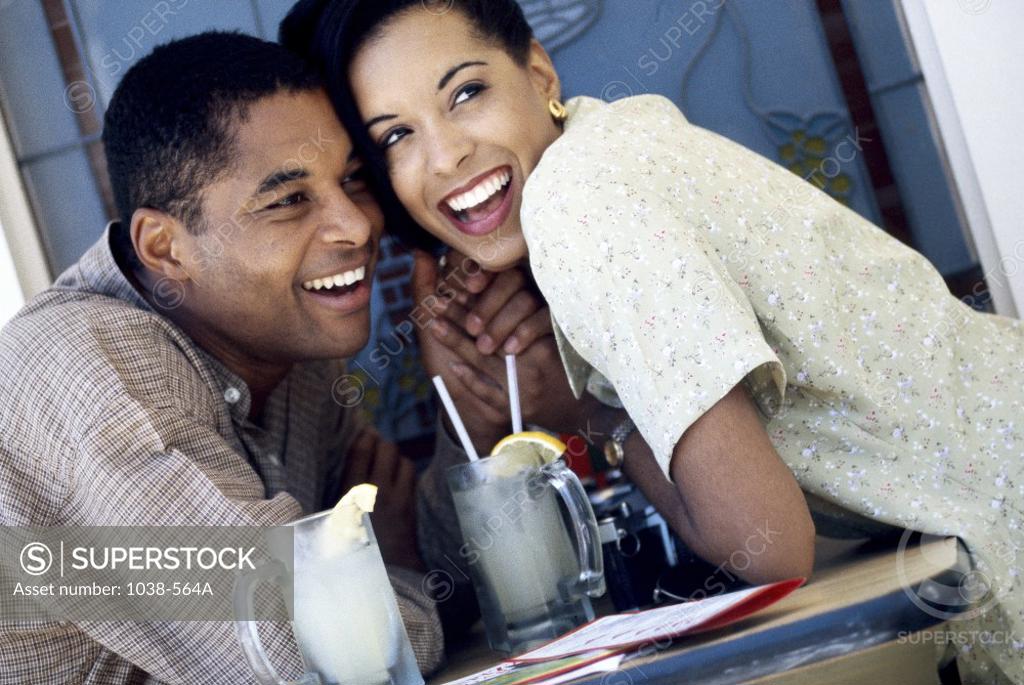 Stock Photo: 1038-564A Young couple holding hands in a restaurant