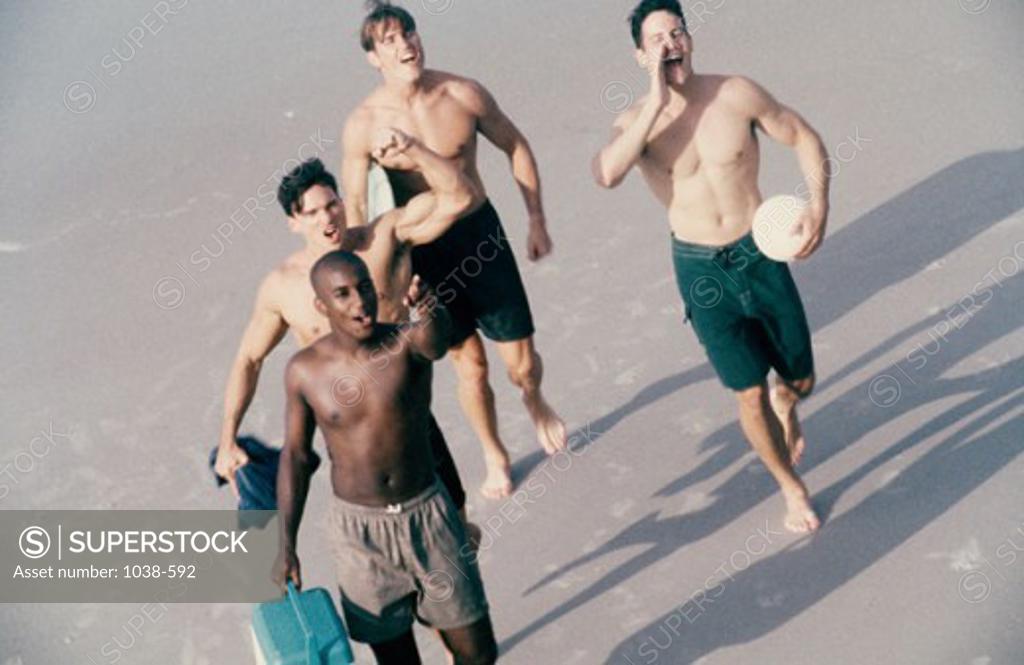Stock Photo: 1038-592 High angle view of four young men walking on the beach