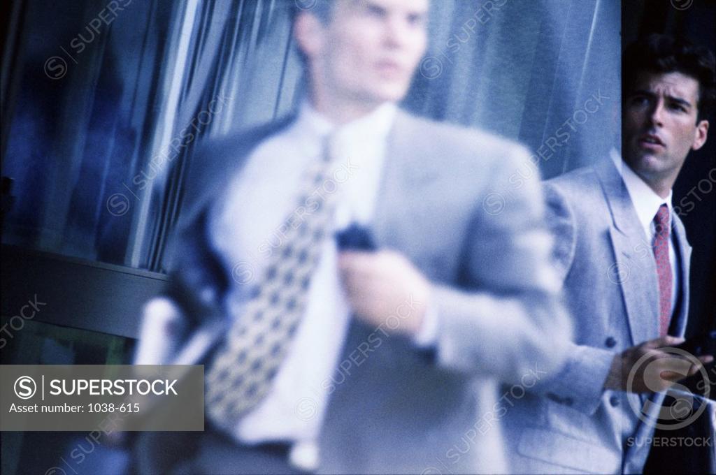 Stock Photo: 1038-615 Two businessmen holding mobile phones