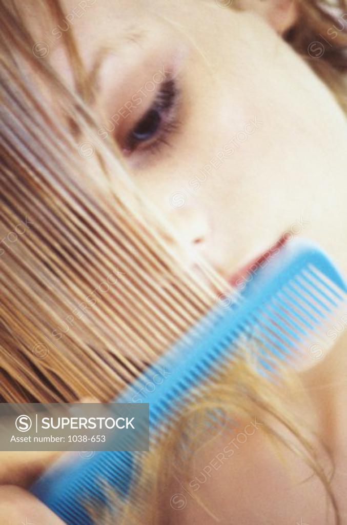 Stock Photo: 1038-653 Close-up of a young woman combing her hair