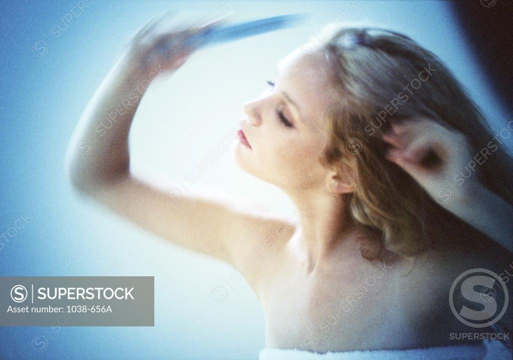 Stock Photo: 1038-656A Young woman combing her hair