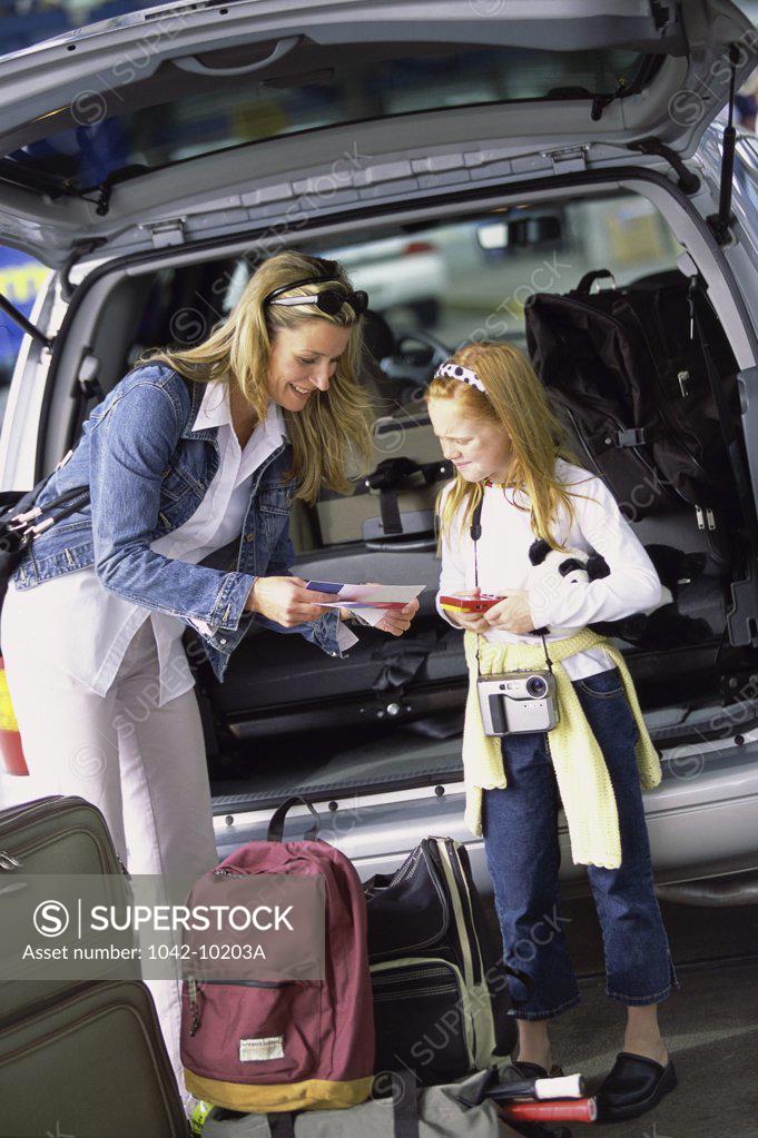 Stock Photo: 1042-10203A Mother and her daughter standing at the back of a car