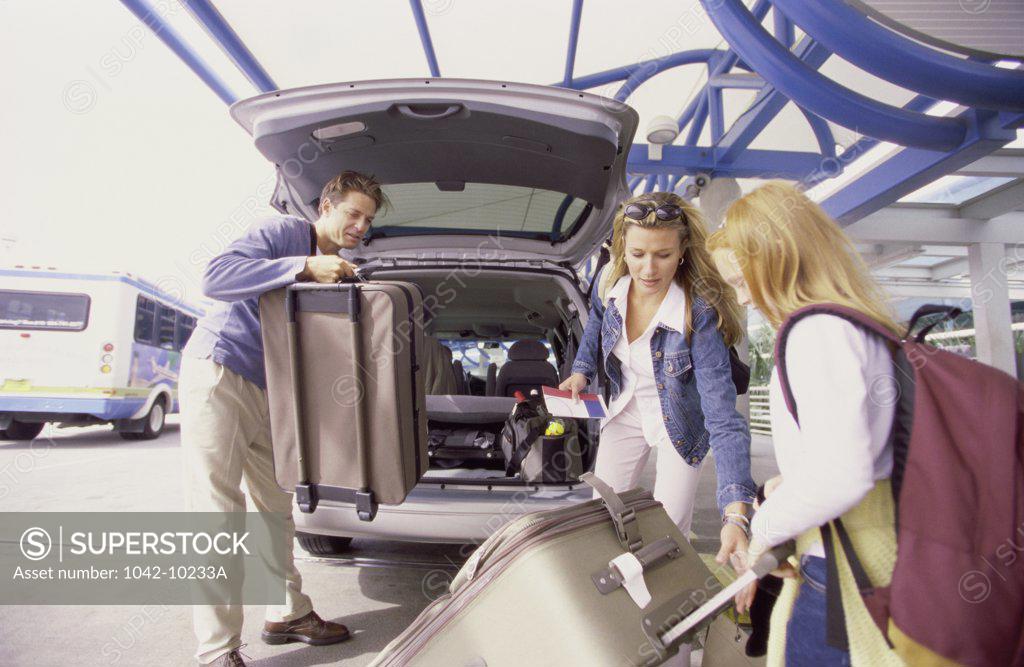 Stock Photo: 1042-10233A Parents with their daughter standing at the back of a car