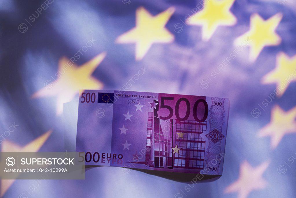 Stock Photo: 1042-10299A Close-up of a euro banknote with the European Union flag in the background