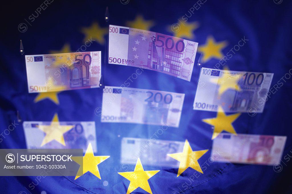 Stock Photo: 1042-10330A Close-up of euro banknotes with the European Union flag in the background