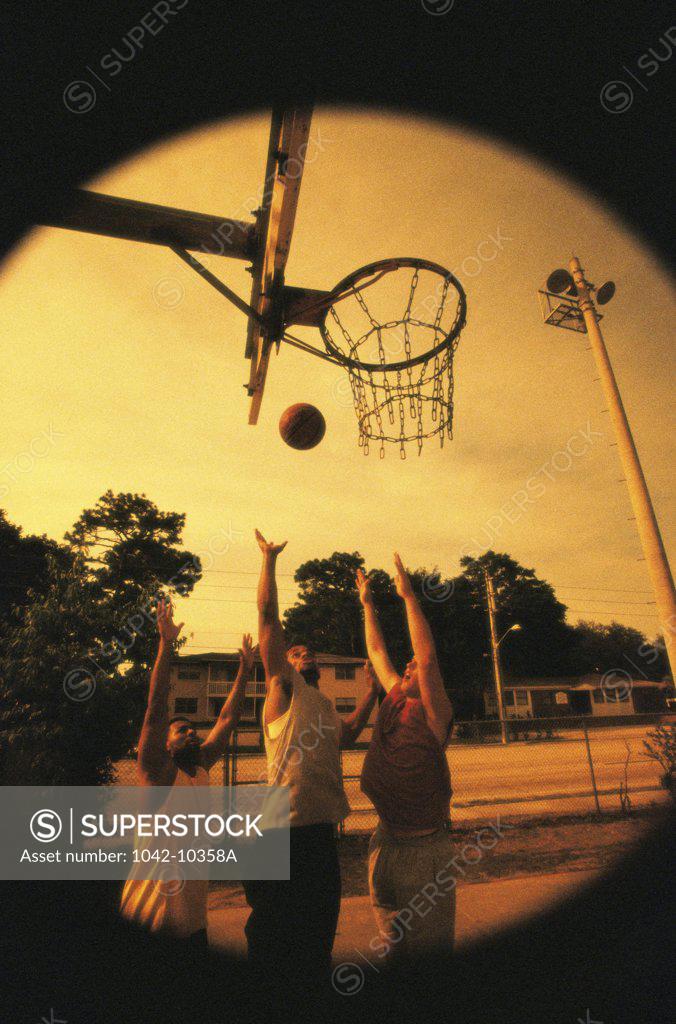 Stock Photo: 1042-10358A Three young men playing basketball
