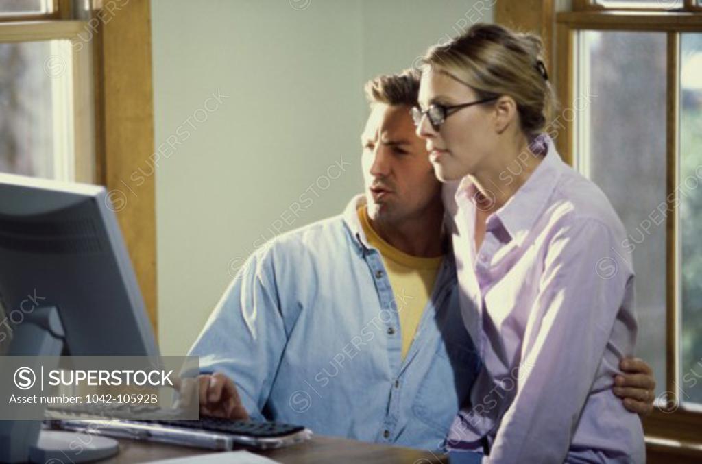 Stock Photo: 1042-10592B Mid adult couple using a computer