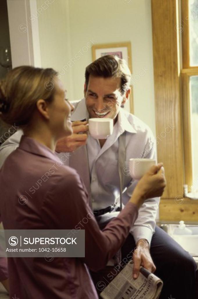 Stock Photo: 1042-10658 Businessman and a businesswoman drinking coffee in the kitchen