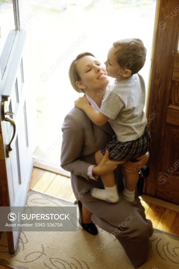 Stock Photo: 1042-10675A High angle view of a son greeting his mother at the front door