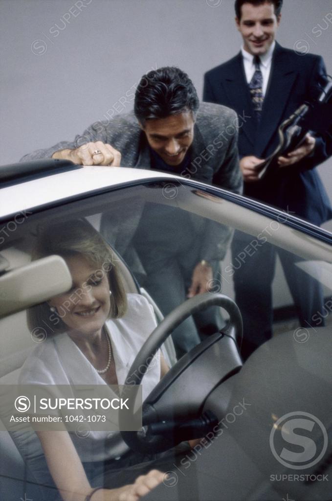 Stock Photo: 1042-1073 Mid adult woman sitting in a car in a showroom