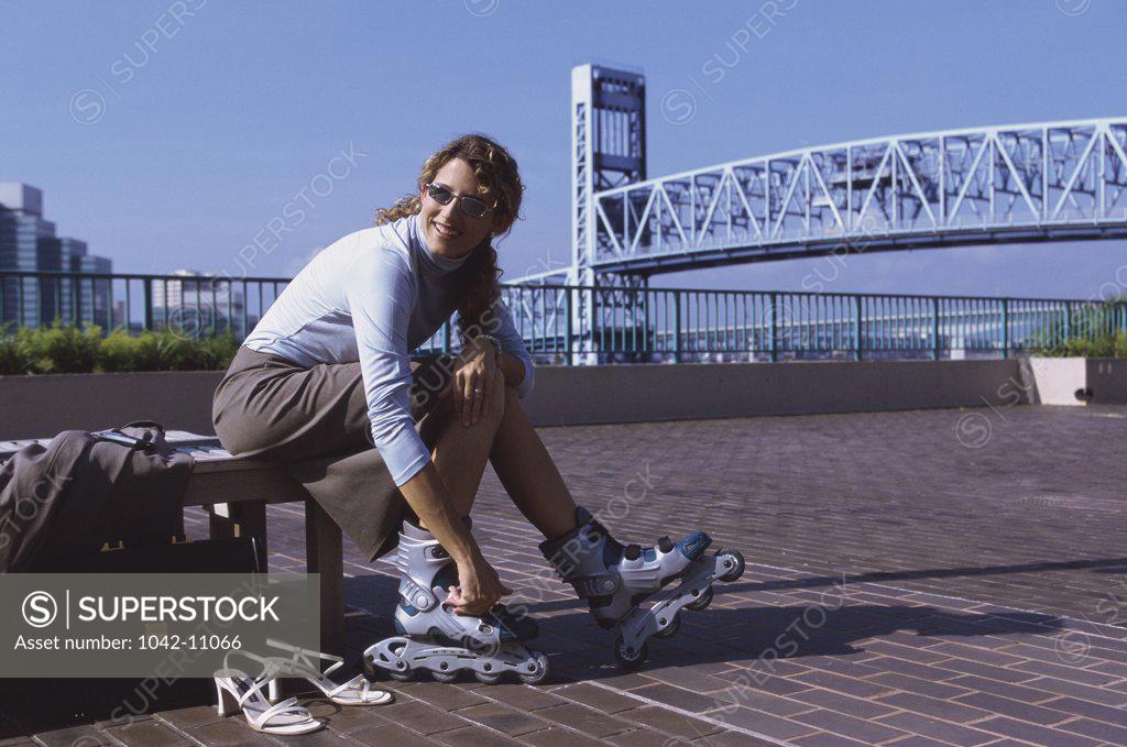 Stock Photo: 1042-11066 Businesswoman putting on inline skates