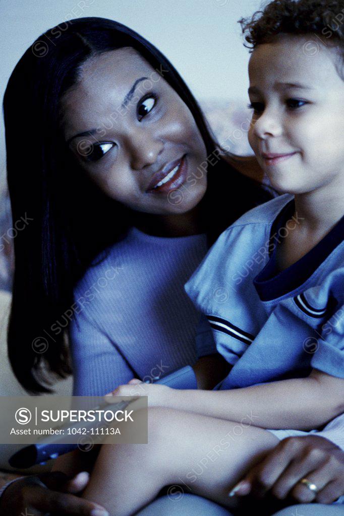 Stock Photo: 1042-11113A Close-up of a young woman watching television with her son