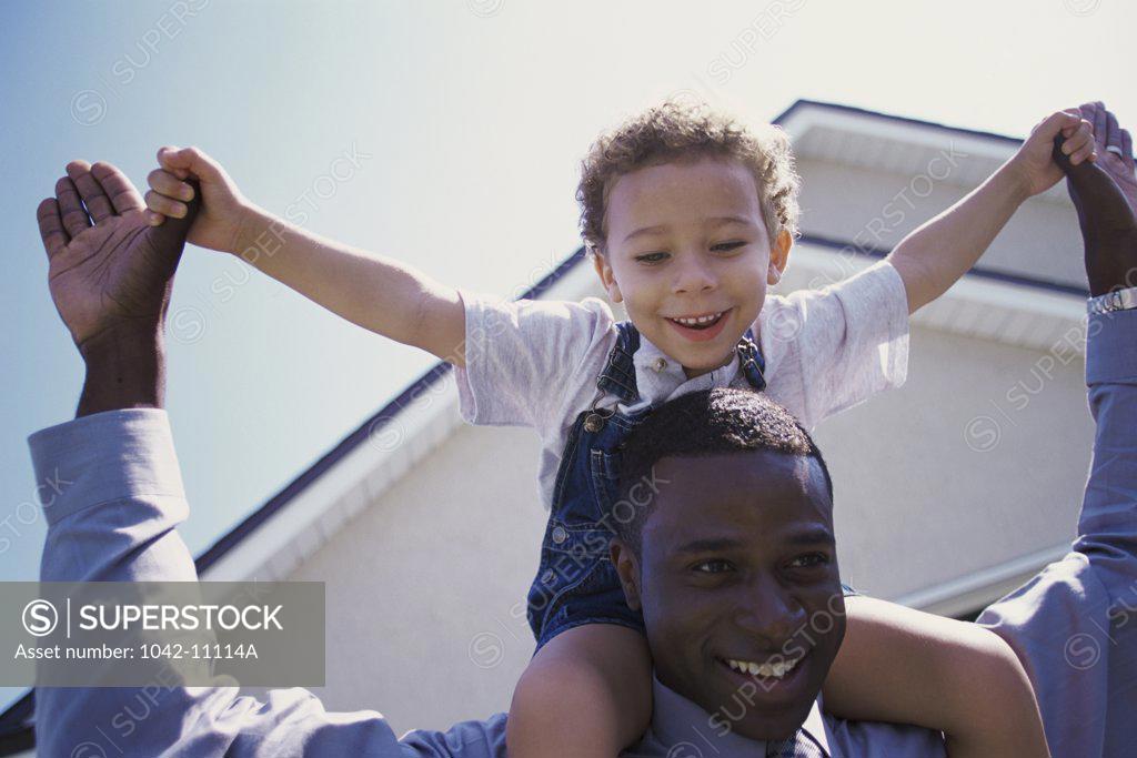 Stock Photo: 1042-11114A Father carrying his son on his shoulders
