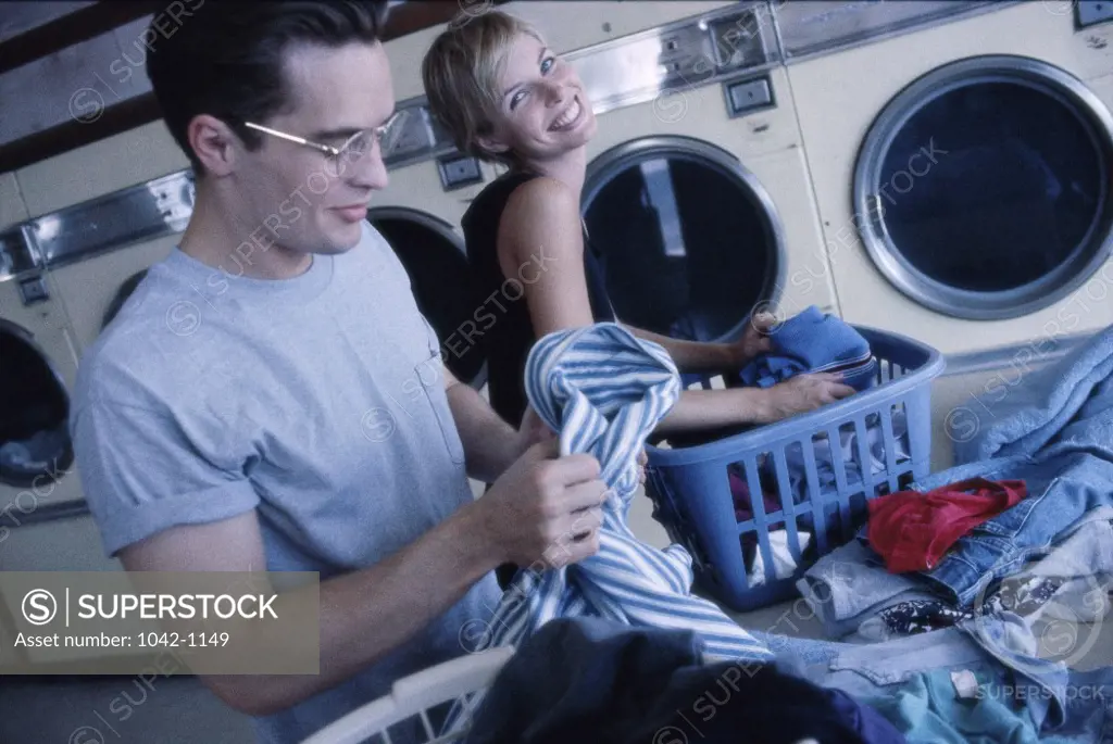 Young couple working in a laundromat