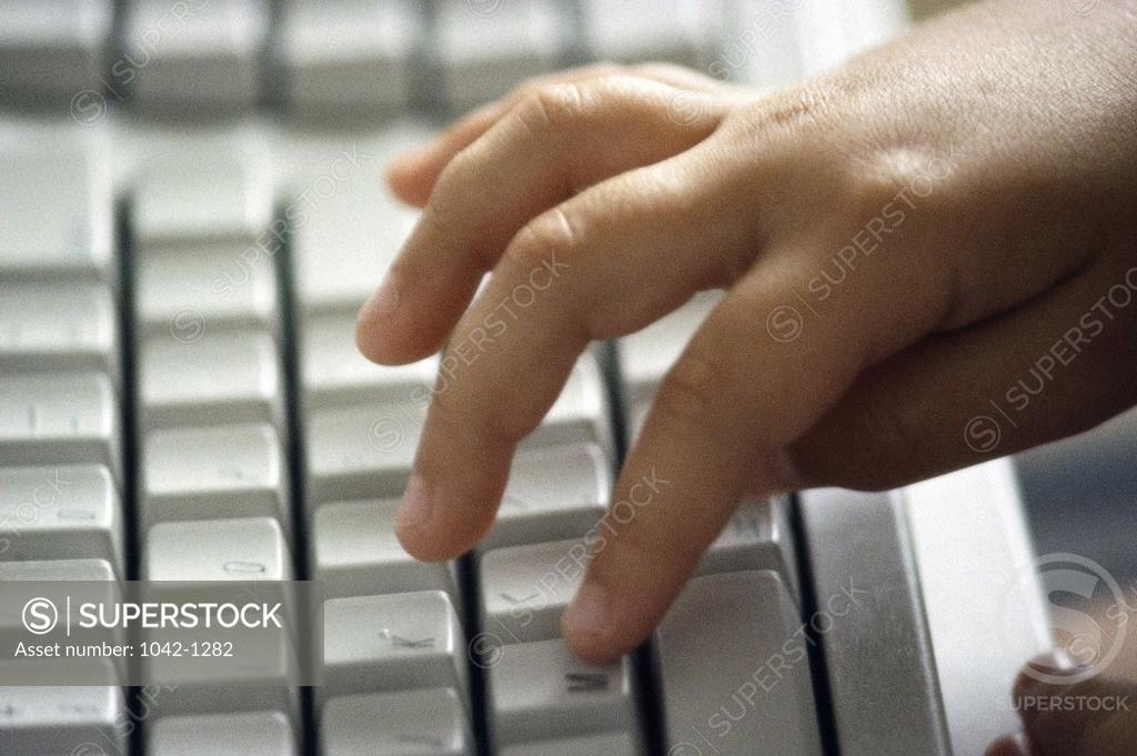 Stock Photo: 1042-1282 Close-up of a child's hand typing on a computer keyboard