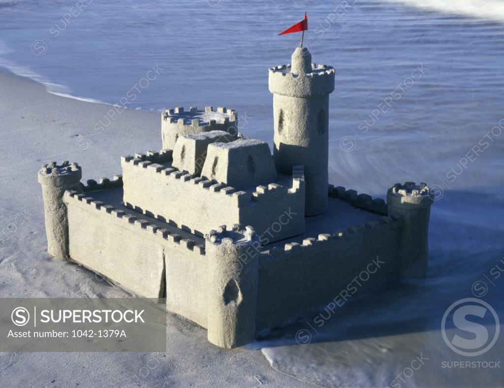 Stock Photo: 1042-1379A Sandcastle on the beach with a red flag