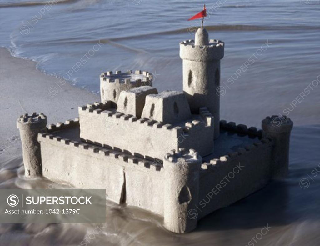 Stock Photo: 1042-1379C Sandcastle on the beach with a red flag