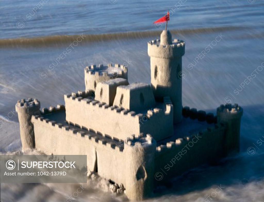 Stock Photo: 1042-1379D Sandcastle on the beach with a red flag