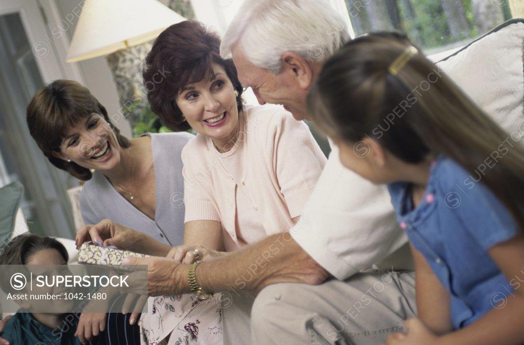 Stock Photo: 1042-1480 Family sitting together unwrapping gifts