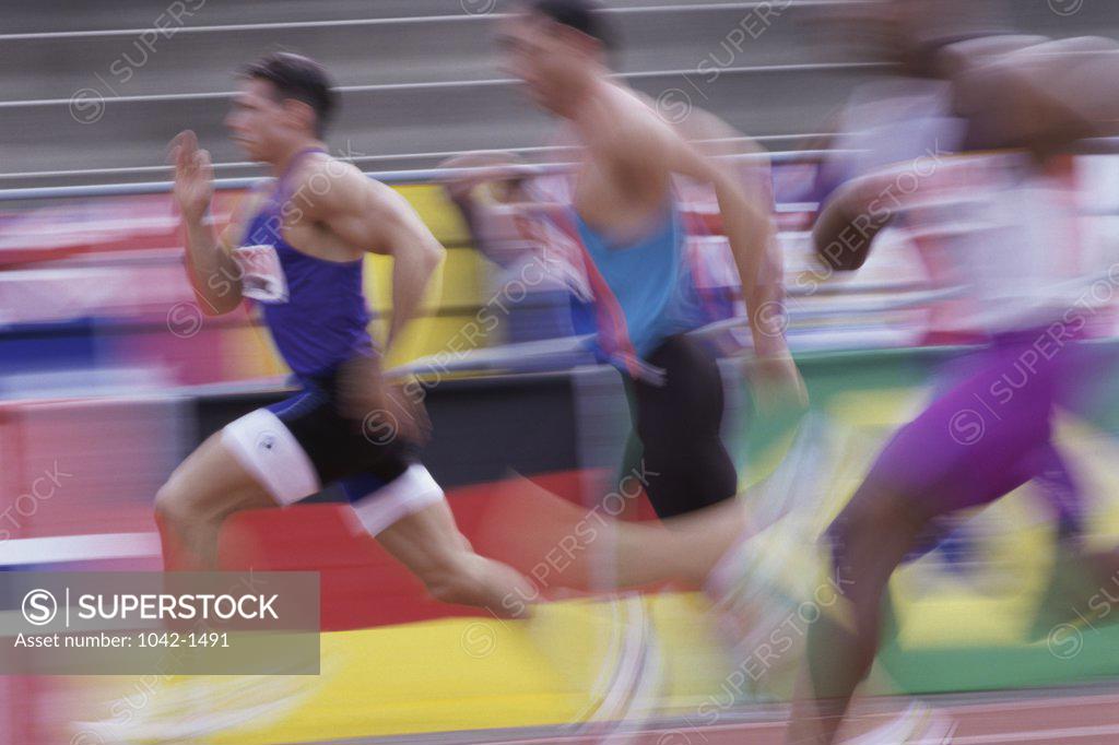 Stock Photo: 1042-1491 Side profile of three men running on a running track