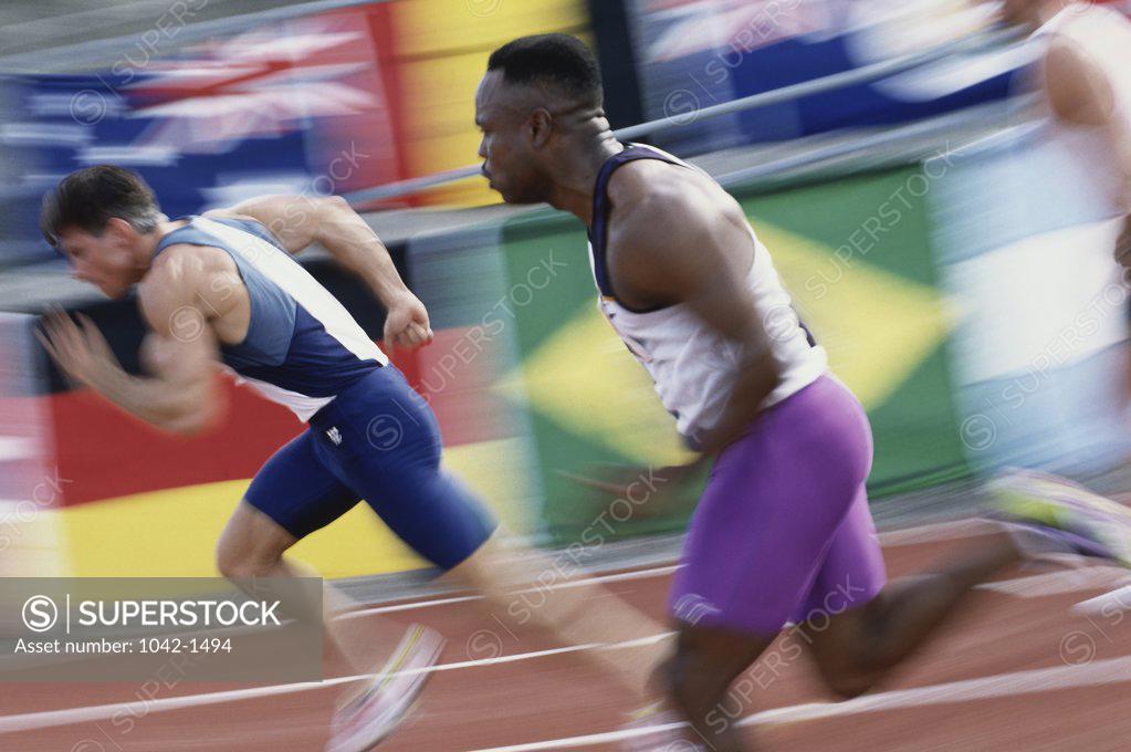 Stock Photo: 1042-1494 Side profile of two young men running on a running track