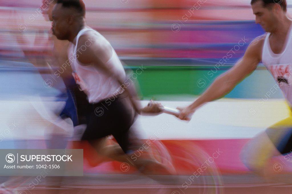 Stock Photo: 1042-1506 Relay racer passing baton to another racer