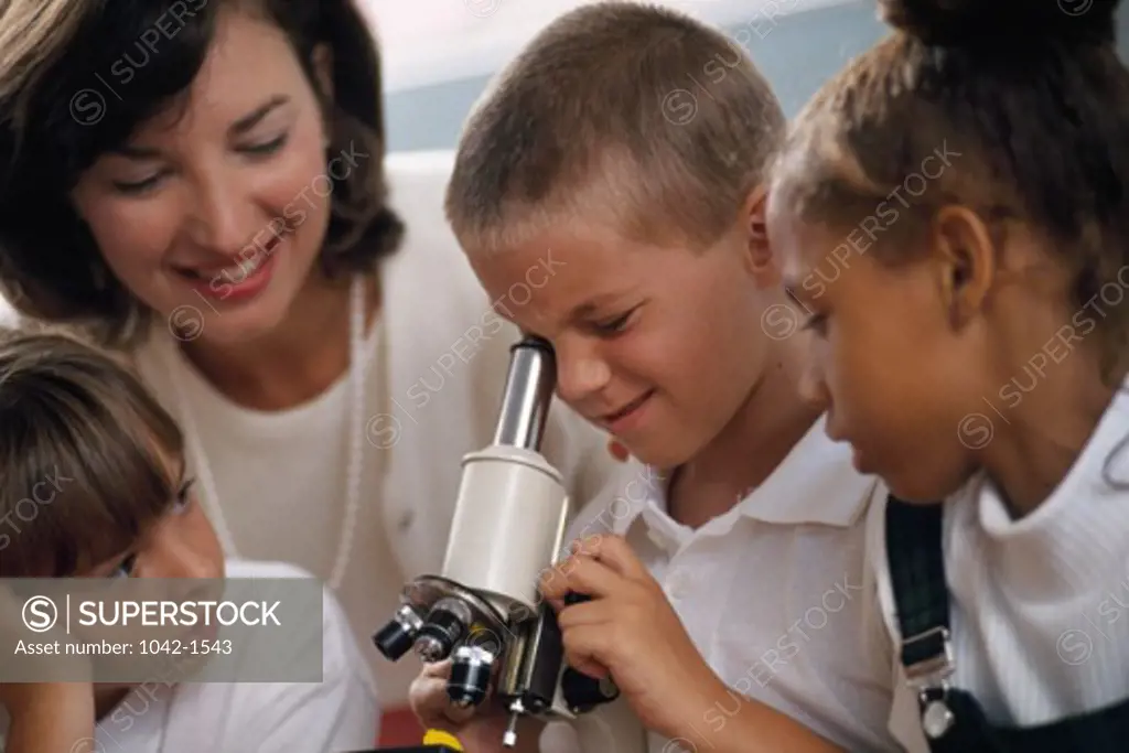 Students looking through a microscope in a classroom