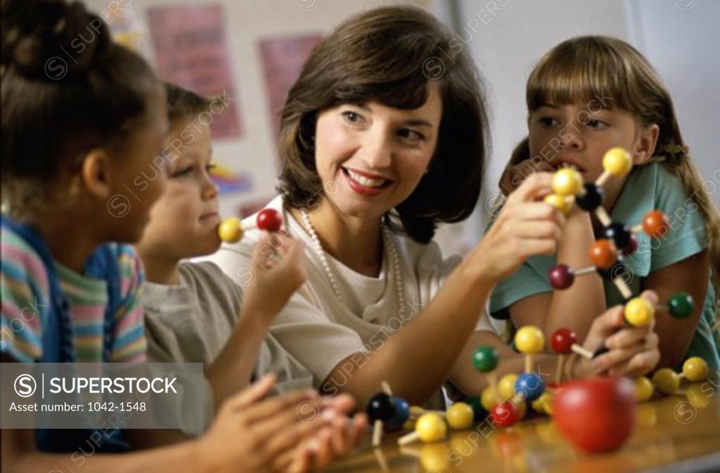 Stock Photo: 1042-1548 Teacher teaching her children about a molecular structure