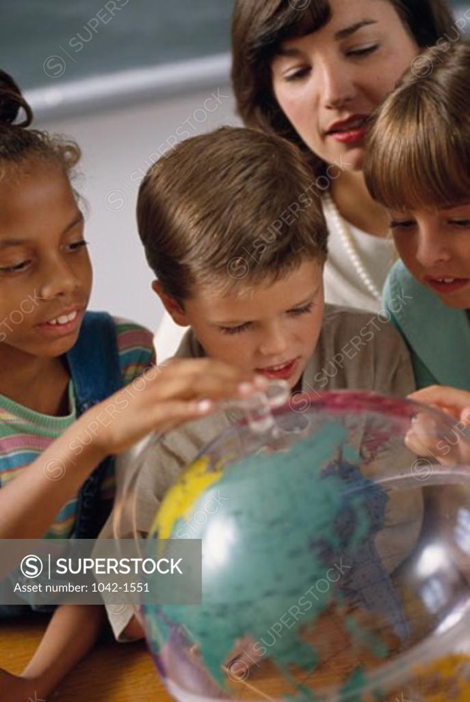 Stock Photo: 1042-1551 Teacher with her students studying the globe