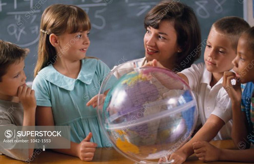 Stock Photo: 1042-1553 Teacher with her students studying the globe