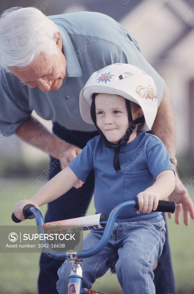 Grandfather teaching his grandson to ride a bicycle