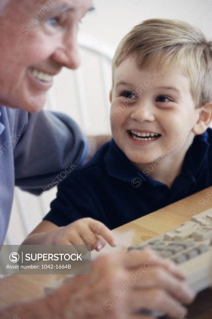 Stock Photo: 1042-1664B Grandfather and his grandson using a computer