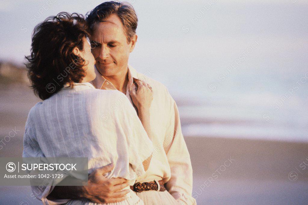 Stock Photo: 1042-1729 Couple holding each other standing on the beach