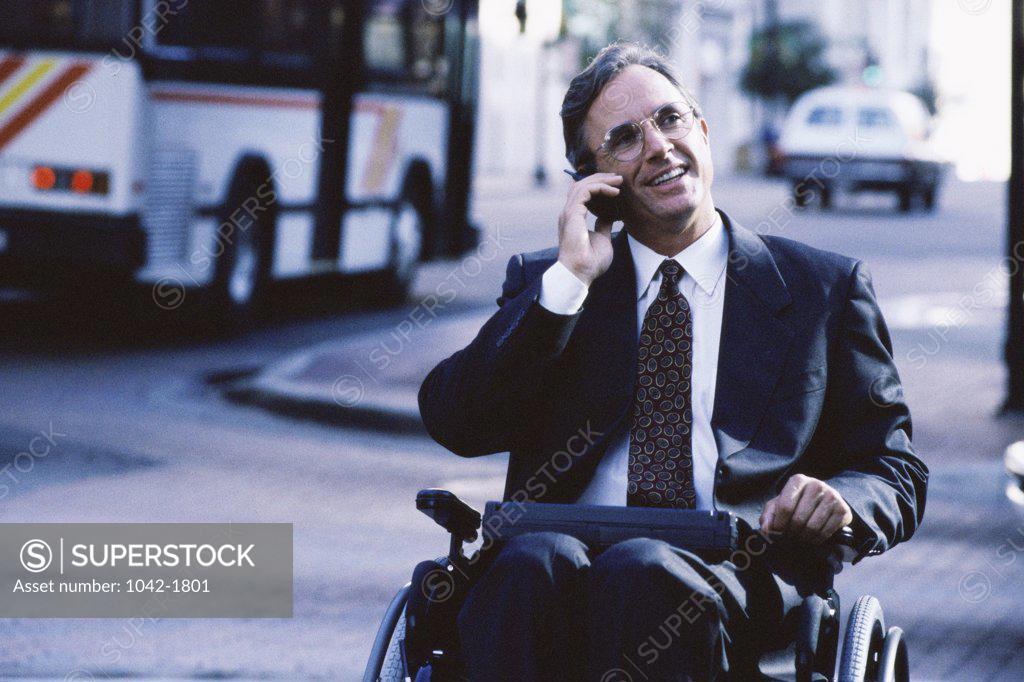 Stock Photo: 1042-1801 Close-up of a businessman in a wheelchair talking on a mobile phone