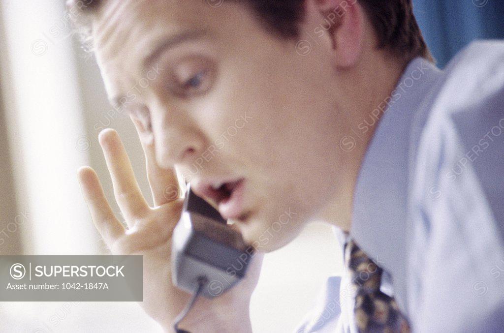 Stock Photo: 1042-1847A Side profile of a businessman talking on the telephone