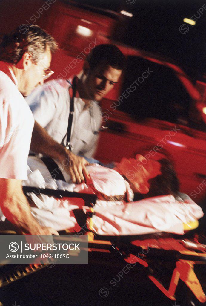 Stock Photo: 1042-1869C Two paramedics pushing a patient on a stretcher