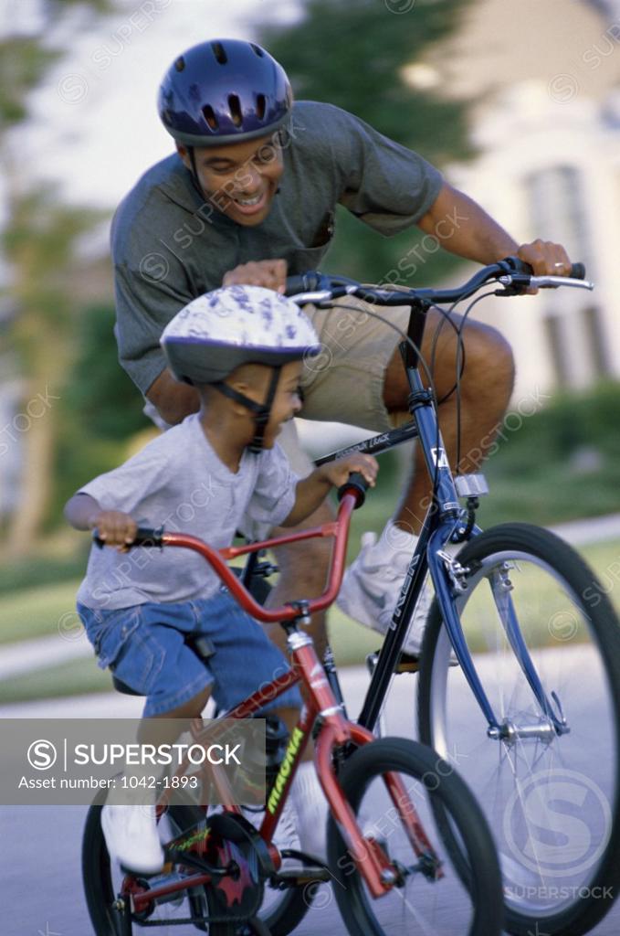 Stock Photo: 1042-1893 Father and his son riding a bicycle