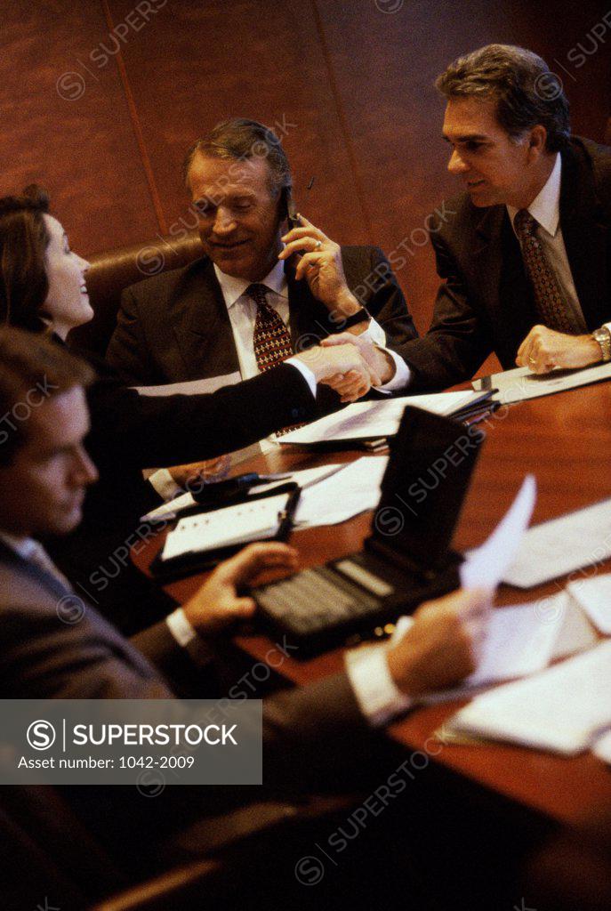 Stock Photo: 1042-2009 Three businessmen and a businesswoman in a conference room