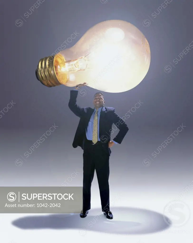 Businessman holding a light bulb over his head