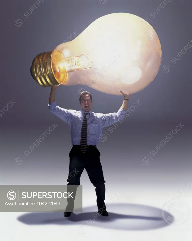 Businessman holding a light bulb over his head
