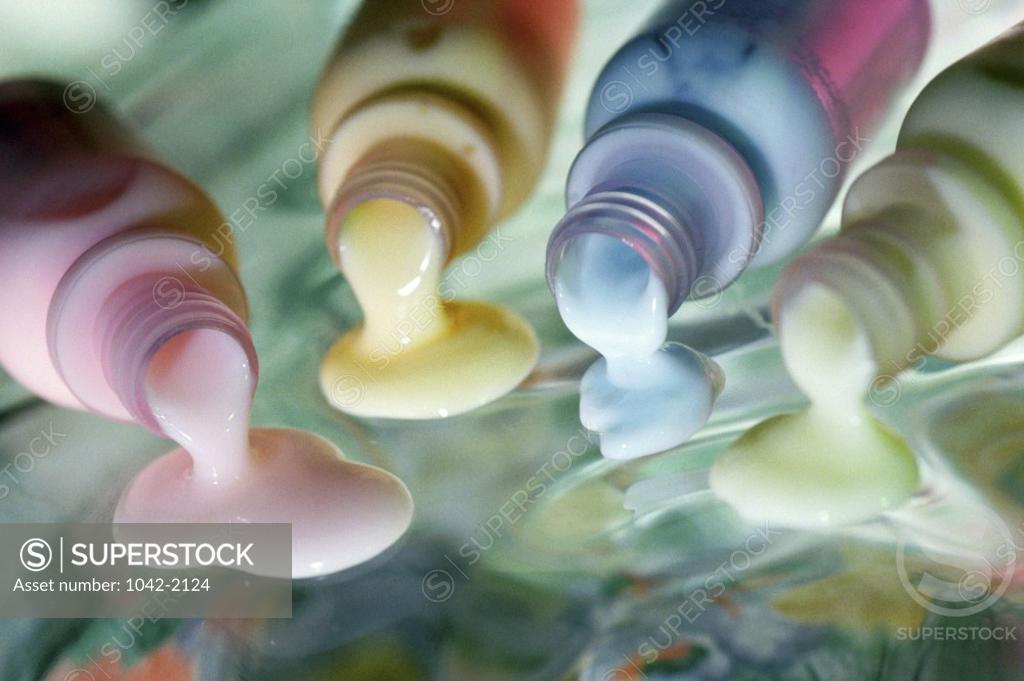 Stock Photo: 1042-2124 Close-up of different colored lotion spilling out from bottles