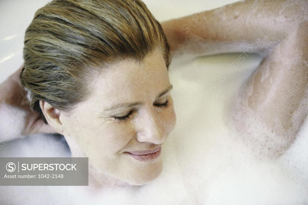 Stock Photo: 1042-2148 Mid adult woman lying in a bathtub