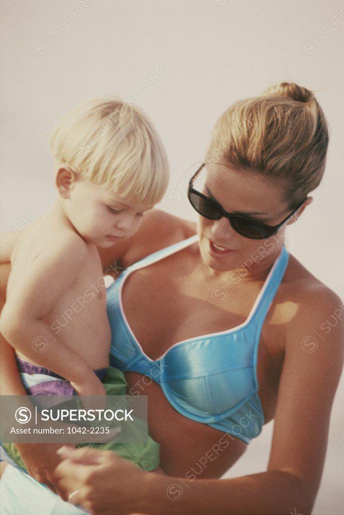Stock Photo: 1042-2235 Mother carrying her son