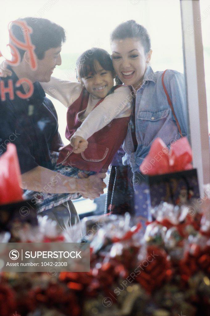 Stock Photo: 1042-230B Parents with their daughter looking at the window display of a store